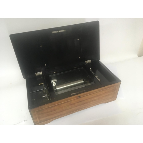 815 - A Victorian Musical box in an inlaid walnut case playing six Airs. Working and with no broken comb p... 