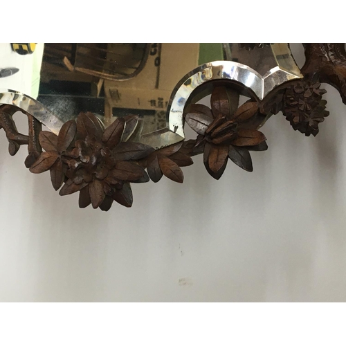 847 - A Quality Black Forest carved wood mirror the top with a bird of prey with glass eyes with a shaped ... 