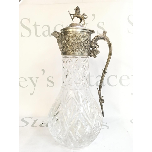 1112 - A cut glass jug with a lion and shield figure topper , 32cm tall. No obvious large damage or restora... 