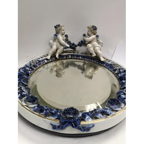 1135 - A Dresden Porcelain oval mirror with raised cherubs flowers and foliage. 33 cm .