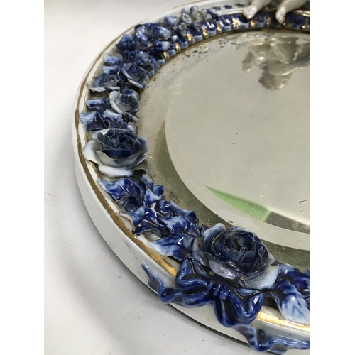 1135 - A Dresden Porcelain oval mirror with raised cherubs flowers and foliage. 33 cm .