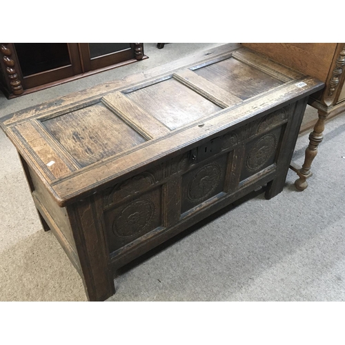 1235 - A late 18th century English oak vernacular chest with a hinged panel top above further carved panels... 