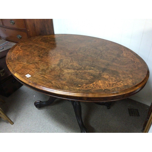 1237 - A quality Victorian burr walnut inlaid loo table the oval hinges top on a carved base with scroll fe... 