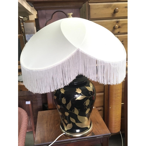 1265 - A modern mid 20th century black and gold leaf design lamp. 70cm tall. This lot cannot be posted