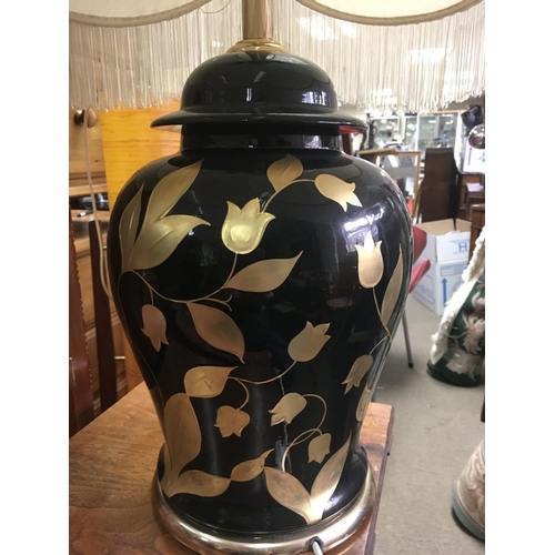 1265 - A modern mid 20th century black and gold leaf design lamp. 70cm tall. This lot cannot be posted