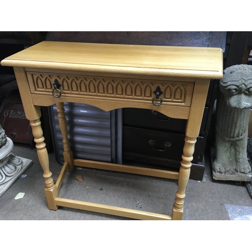 1296 - A light oak side table with single drawer on turned legs united with under stretch.