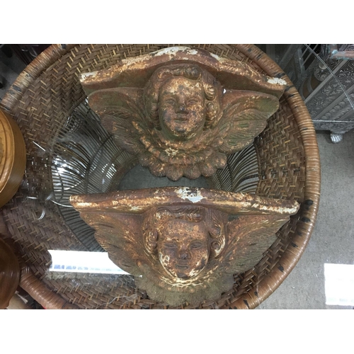 2058 - A pair of cherub cast iron wall planters, 34cm wide. This lot cannot be posted