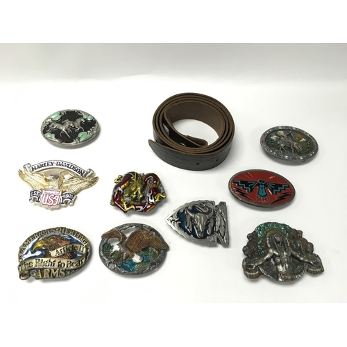 706 - A collection of 9 belt buckles with a new leather belt. Postage B