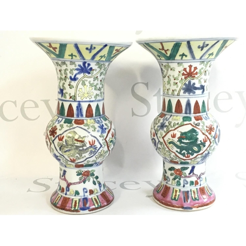 865 - A pair of Chinese Wucai dragon vases, six character marks on the bases. 24cm tall. This lot cannot b... 