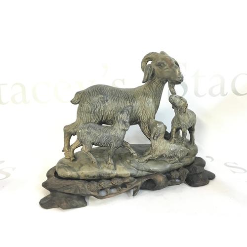 881 - A Chinese soapstone goat figure with a wooden base , 18cm tall. This lot cannot be posted