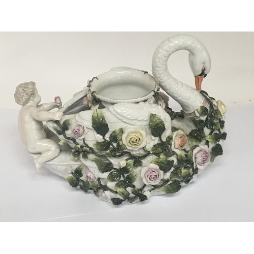 932 - A German late 19th century porcelain jardiniere ornament in the form of a swan encrusted with raised... 