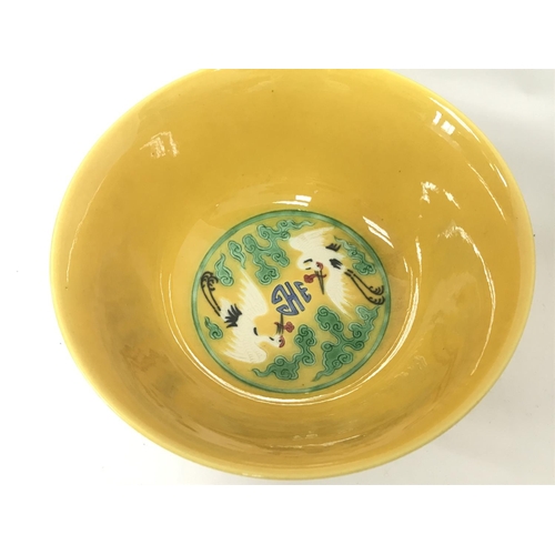 828 - A Chinese yellow glaze bowl with decoration of cranes. 15cm wide. This lot cannot be posted