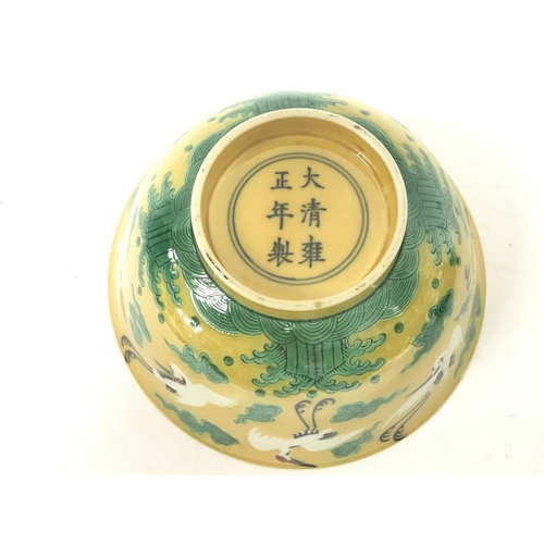 828 - A Chinese yellow glaze bowl with decoration of cranes. 15cm wide. This lot cannot be posted