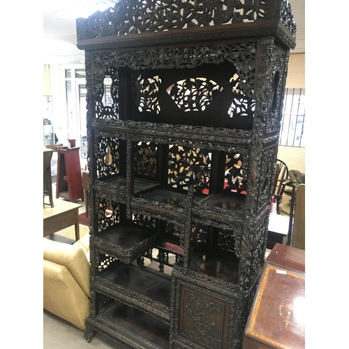 1317 - A Chinese display cabinet profusely carved with open sections single cupboard door and drawer on bal... 