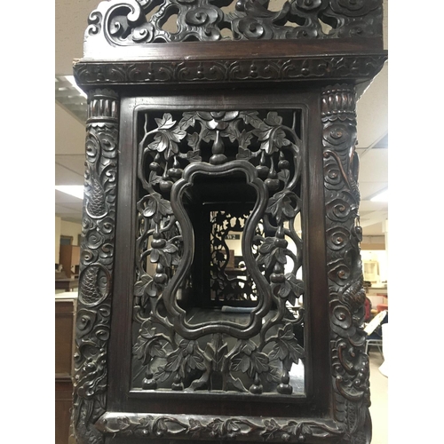 1317 - A Chinese display cabinet profusely carved with open sections single cupboard door and drawer on bal... 