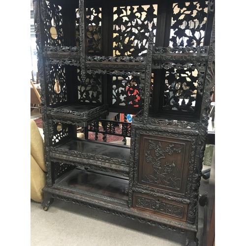 1317 - A Chinese display cabinet profusely carved with open sections single cupboard door and drawer on bal... 