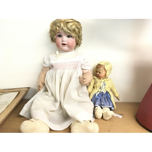 2099 - A large early 20th century doll with bisque head and composition body and one other doll. Postage D