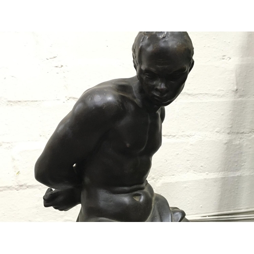 809 - A bronze lamp base figure of a seated man in captivity. 50cm tall approximately. This lot cannot be ... 