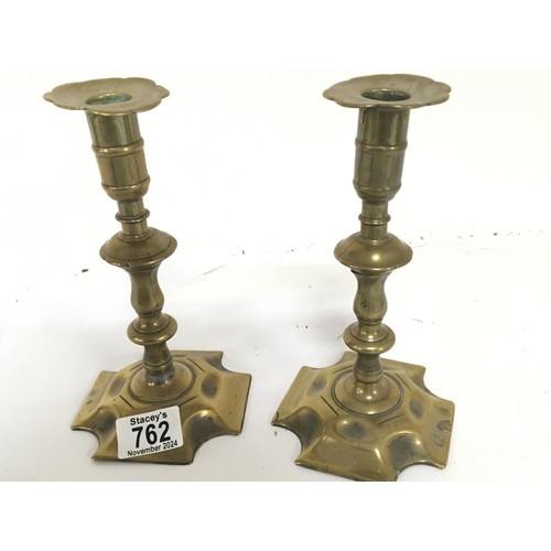 823 - A pair of 18th Century brass candle sticks. With shaped stems and bases with visible seem. Height 20... 