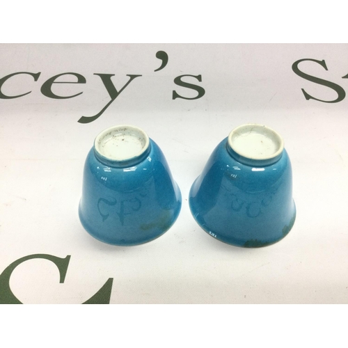 939 - Two rice wine cups in blue, one with a white interior and cracked, approx height 4.5cm. Shipping cat... 