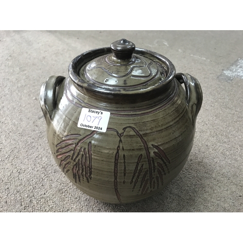 225 - A jar and cover with raised side handles, dark green glaze incised decoration and impressed potters ... 