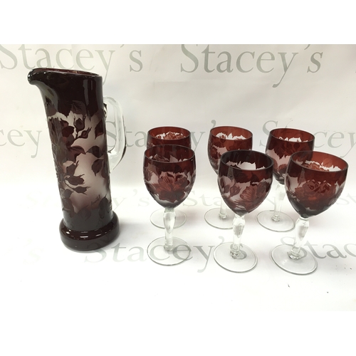 319 - A set of cameo ruby flash wine glasses and a pitcher.