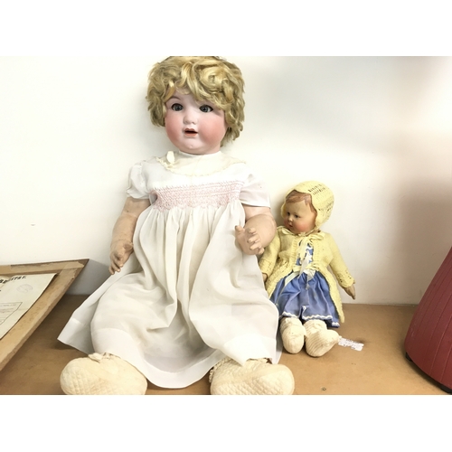 383 - A large early 20th century doll with bisque head and composition body and one other doll. Postage D.... 