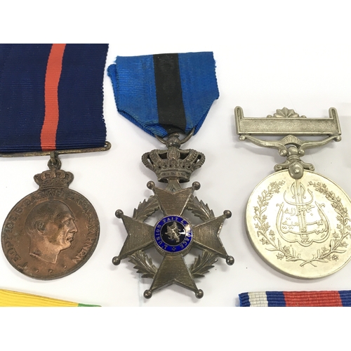 411 - A Collection of military medals including a China 1954 merit, Polish peoples public medal, Belgium T... 