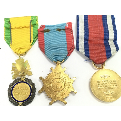 411 - A Collection of military medals including a China 1954 merit, Polish peoples public medal, Belgium T... 