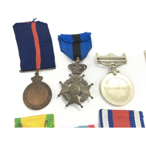 411 - A Collection of military medals including a China 1954 merit, Polish peoples public medal, Belgium T... 