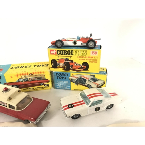 344 - A Boxed Corgi Superior Ambulance #437. A Lotus-Climax F/1 #158. And a Ford Mustang #325.