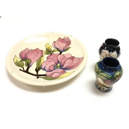 1017 - A Moorcroft Magnolia plate and two small vases. This lot cannot be posted.