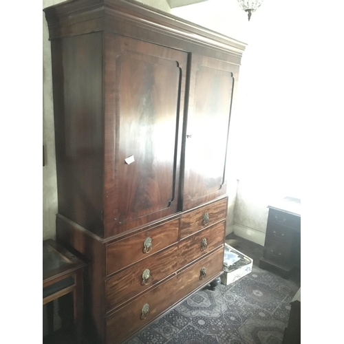 1231 - A late George III mahogany linen press with a cornice above cupboard door enclosing sliding shelves ... 