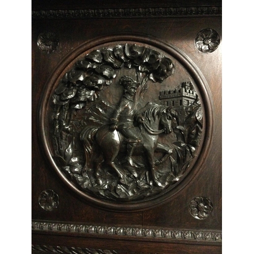 1252 - A large oak sideboard profusely carved with figures horses flower heads And foliage the raised back ... 