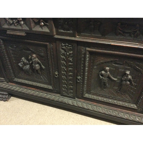 1252 - A large oak sideboard profusely carved with figures horses flower heads And foliage the raised back ... 