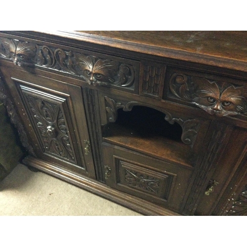 1253 - A oak mirror back sideboard the raised back above two drawers and cupboards under on ball shaped fee... 