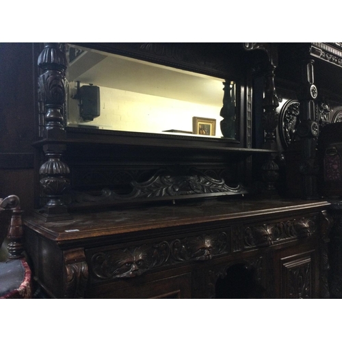 1253 - A oak mirror back sideboard the raised back above two drawers and cupboards under on ball shaped fee... 