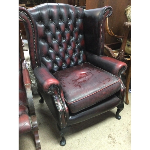 1262 - A red leather wing armchair with button back on cabriole cabriole legs .