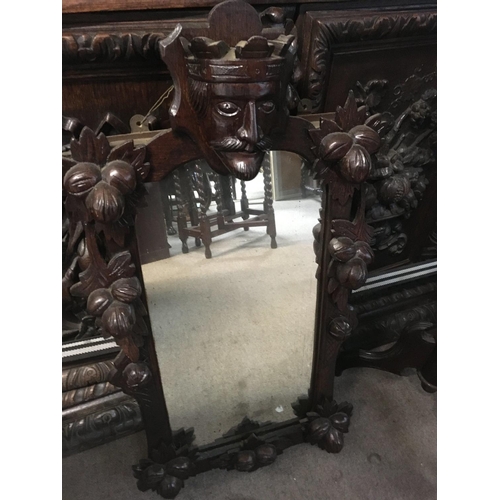 1264 - A small mirror carved with a figure head and a Victorian carved wine table .