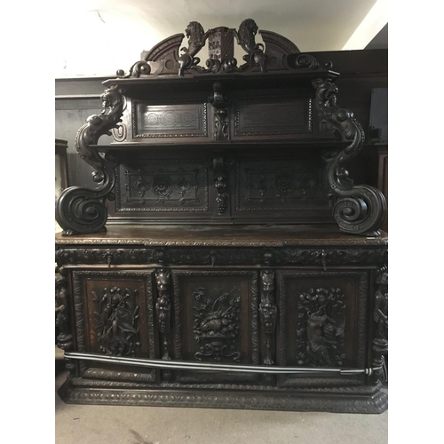 1265 - A large oak Sideboard profusely carved With figures, animals,fruit and foliage the raised back with ... 