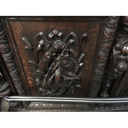 1265 - A large oak Sideboard profusely carved With figures, animals,fruit and foliage the raised back with ... 