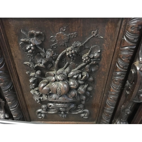 1265 - A large oak Sideboard profusely carved With figures, animals,fruit and foliage the raised back with ... 