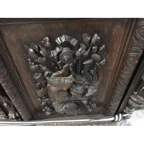 1265 - A large oak Sideboard profusely carved With figures, animals,fruit and foliage the raised back with ... 