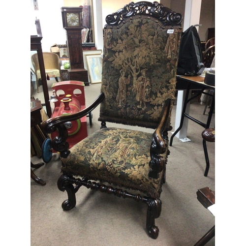 1288 - A Charles II style chair with a carved top rail above pictorial tapestry upholstery with scroll arms... 