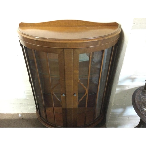 1296 - A bow fronted display case. 87cm wide 36 deep 128cm tall.