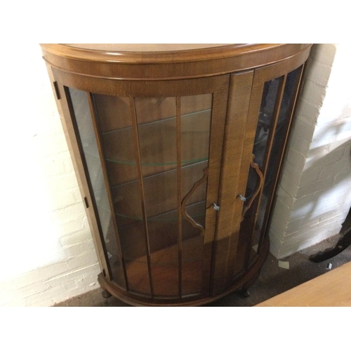 1296 - A bow fronted display case. 87cm wide 36 deep 128cm tall.