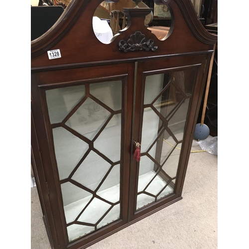 1328 - A mahogany display cabinet the swan neck pediment above a pair of glazed doors.