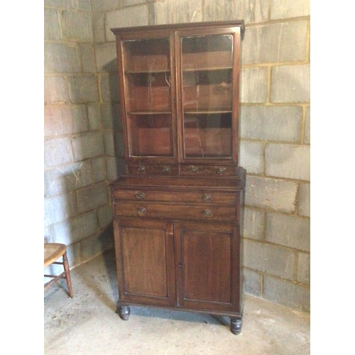 1334 - An Early 19th century late Regency Mahogany cabinet with glazed doors above small drawers and cupboa... 