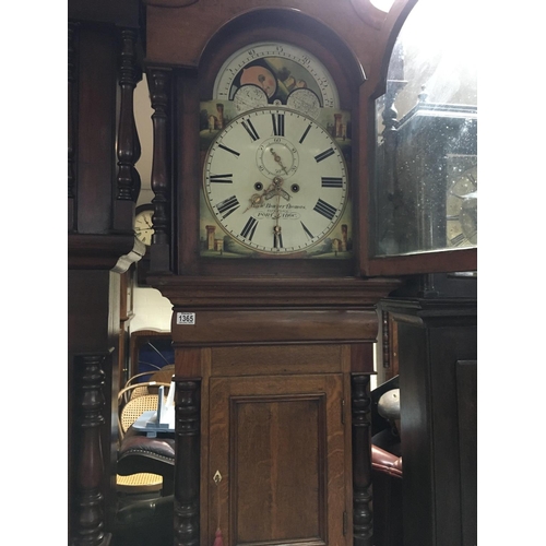 1365 - A oak long case clock the Arched painted dial with Roman numerals.