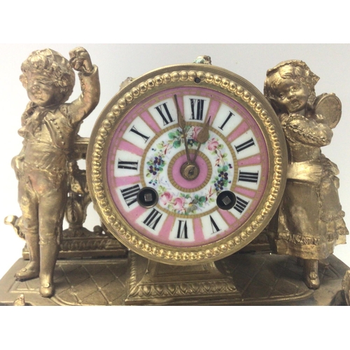 1380 - A French gilt mantle clock with children figures and pink floral panel designs. Damaged and in need ... 